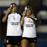 Jogadoras do Corinthians comemoram gol com caneleira na frente dos olhos.