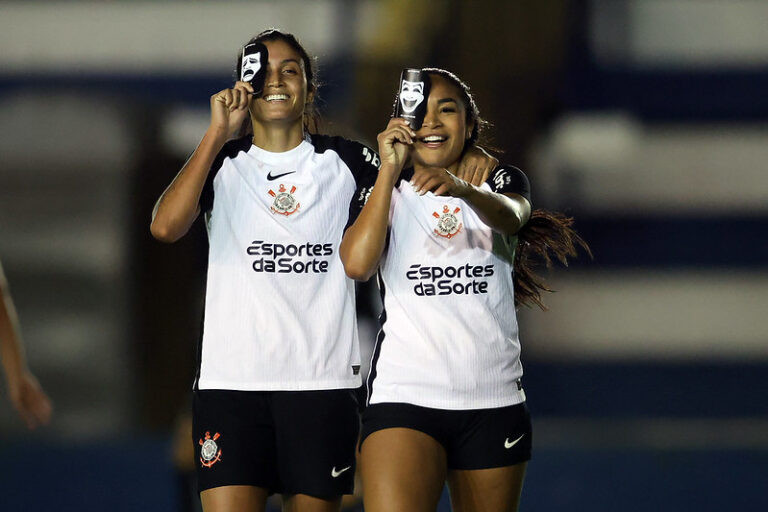 Jogadoras do Corinthians comemoram gol com caneleira na frente dos olhos.