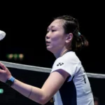 Beiwen Zhang lançando a peteca ao alto