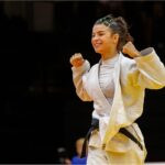 Atleta de Judô, ergue os braços em comemoração