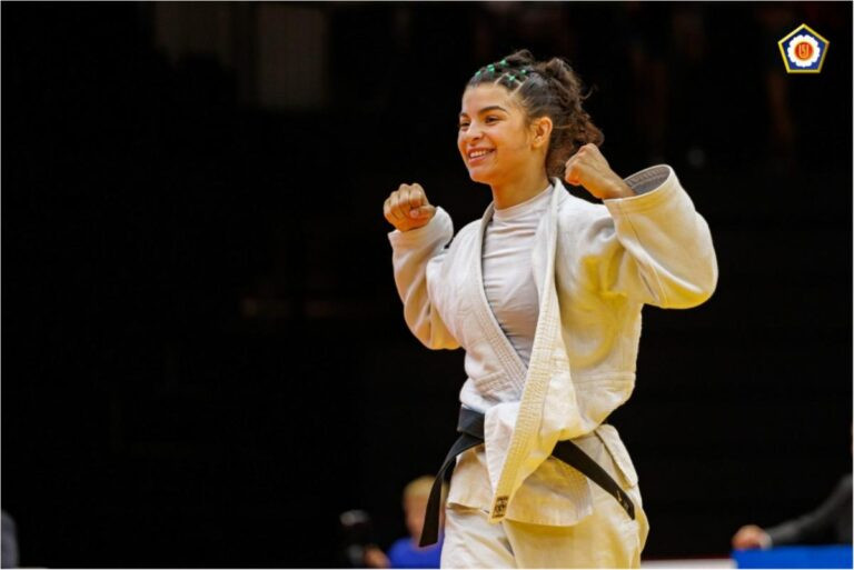 Atleta de Judô, ergue os braços em comemoração