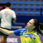Atleta brasileira com raquete erguida