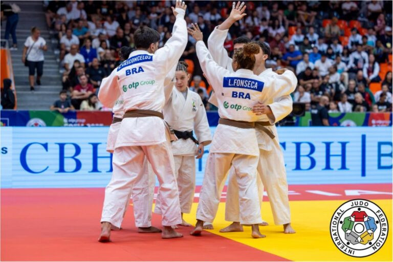 Equipe brasileira se cumprimenta no tatame durante a competição.