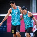 Dupla Guto e André em quadra com a rede ao fundo após derrota