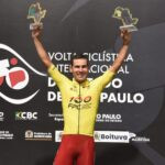 Igor Molina ergue os braços com troféus no pódio