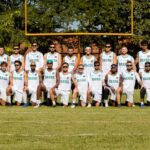 Equipe masculina posa para foto com a trave ao fundo durante treinamentos