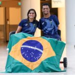 Mariana Gesteira e Gabriel Araújo com bandeira do Brasil ao fundo