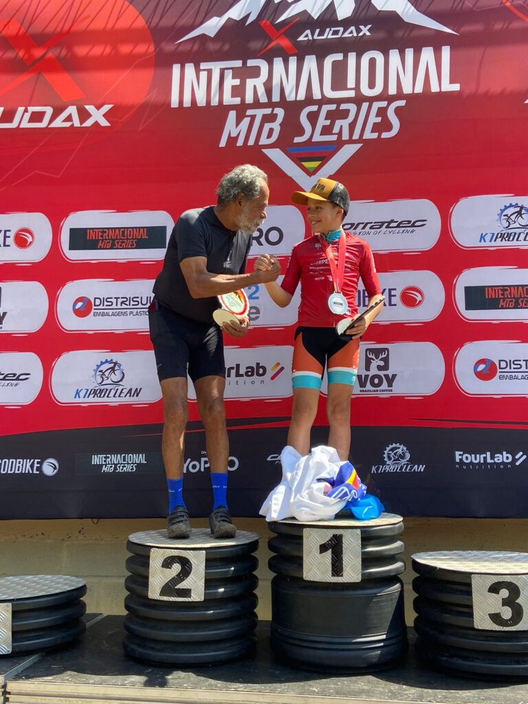 Atleta mais experiente e mais jovem compartilham momento emocionante no Internacional MTB Series 2025 (Foto: Divulgação)
