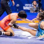 Brasileira no chão, tendo a perna segura por adversária