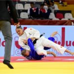 Judocas em combate no solo.