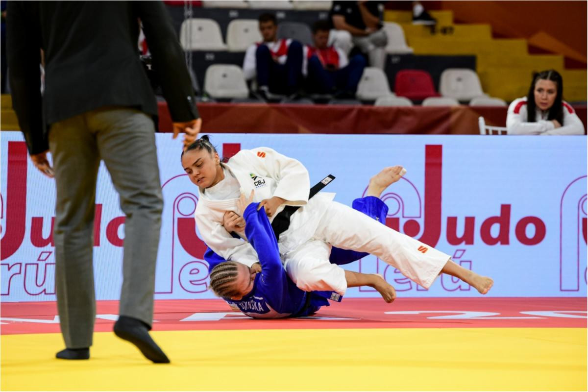 Judocas em combate no solo.