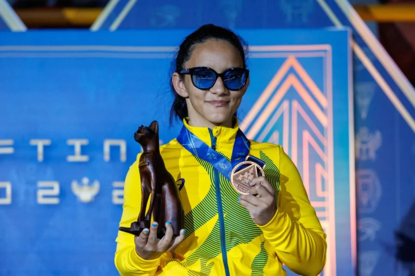 A halterofilista Lara Lima exibe medalha de bronze durante pódio em Cairo | Foto: Alessandra Cabral / CPB
