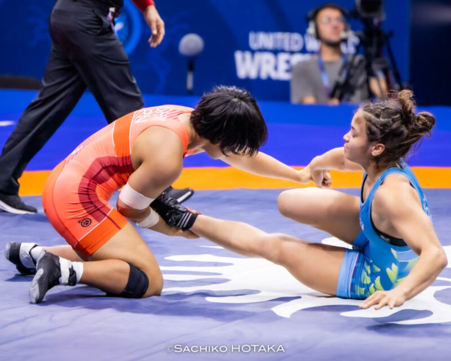 Brasileira no chão, tendo a perna segura por adversária