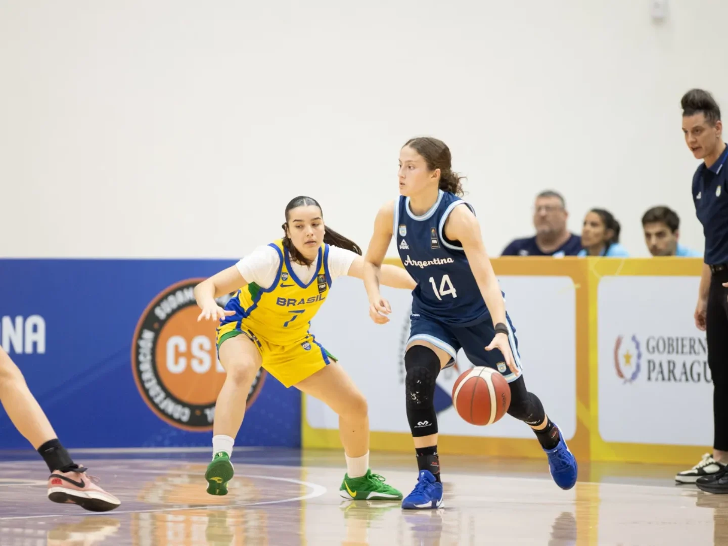 Jogadora argentina conduz a bola sob marcação de brasileira